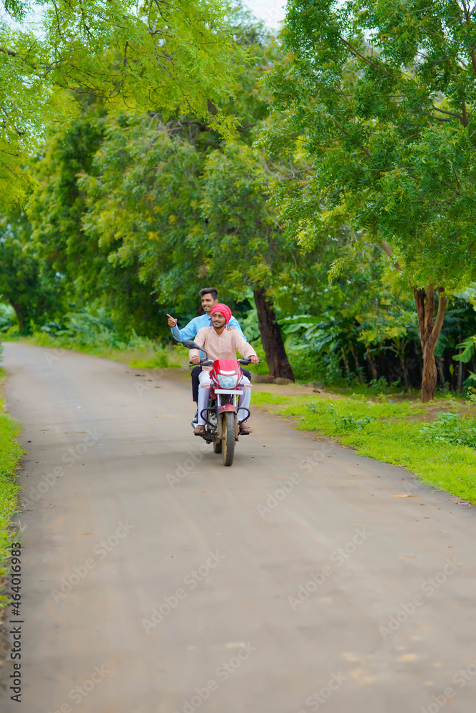 Fototapeta premium Indian agronomist going agriculture field with farmer on bike.