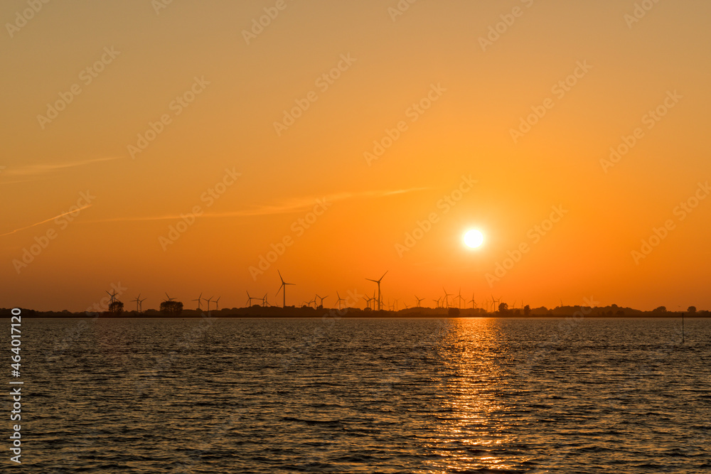 Sunset behind wind turbines near Wischhafen, Germany,  on the Elbe river shore