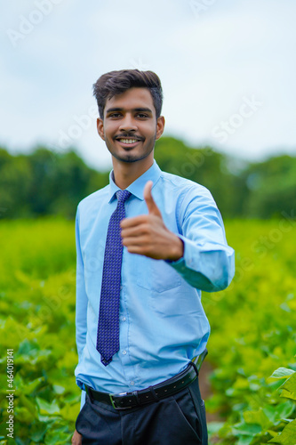 Young indian agronomist standing at agriculture field.