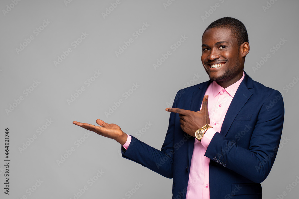 young black businessman pointing to his open palm, advertising concept young black businessman pointing to his open palm, advertising concept