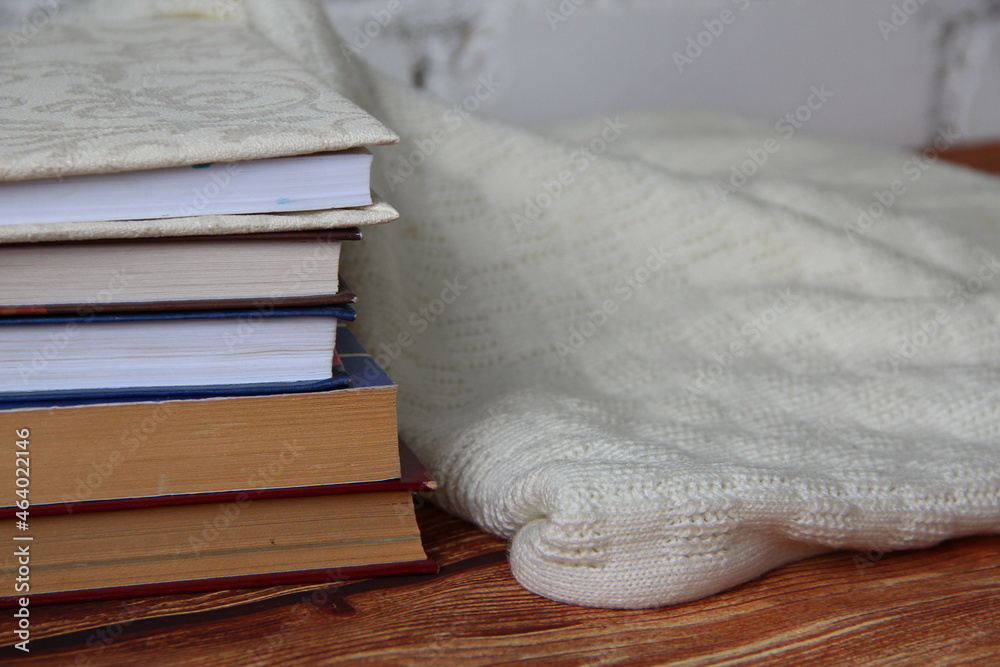 Stack of books and a cozy sweater near Stack of books and a cozy sweater near