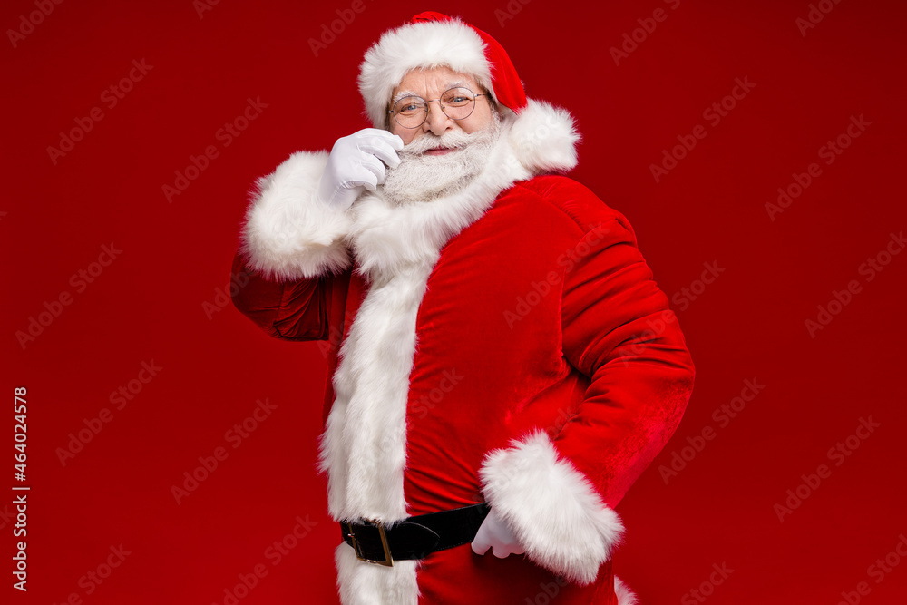 Photo of funky positive retired man wear santa claus costume belt spectacles smiling arm mustaches isolated red color background Photo of funky positive retired man wear santa claus costume belt spectacles smiling arm mustaches isolated red color background