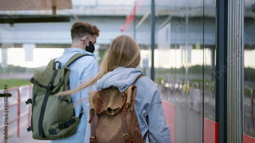 Young couple tourist travelers on holiday at the tram stop in city, coronavirus concept. photo