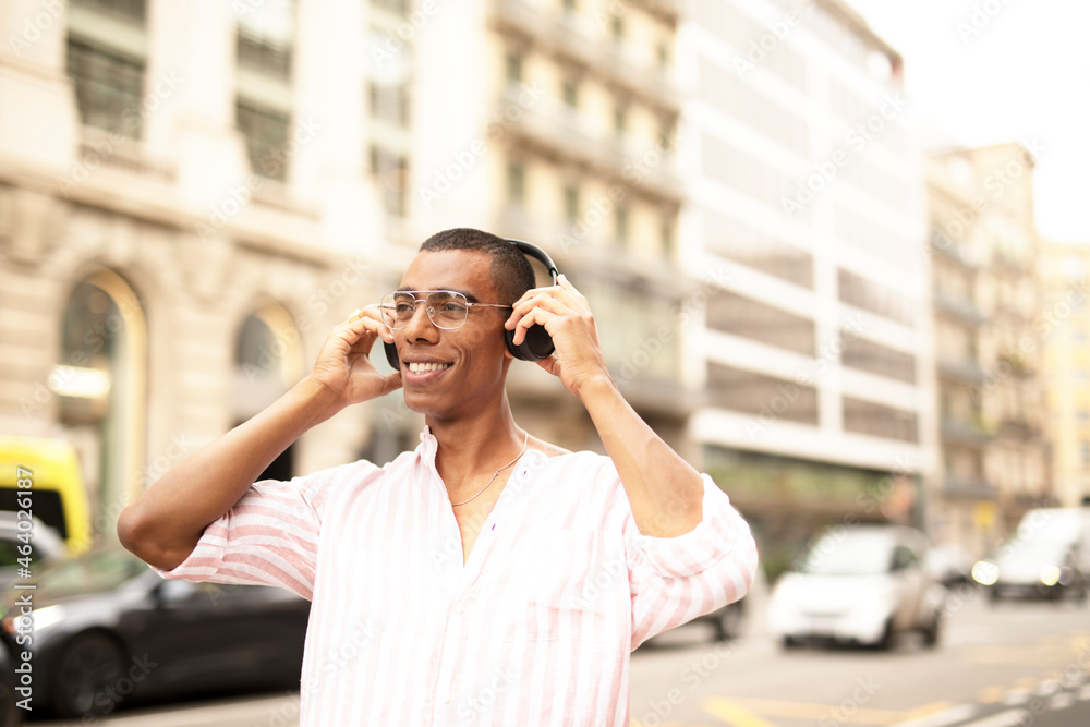 Cheerful guy with the headphones. Young african man listening the music outdoors. Cheerful guy with the headphones. Young african man listening the music outdoors.