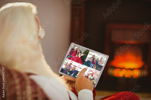 Caucasian santa claus on christmas laptop video call with diverse group of friends
