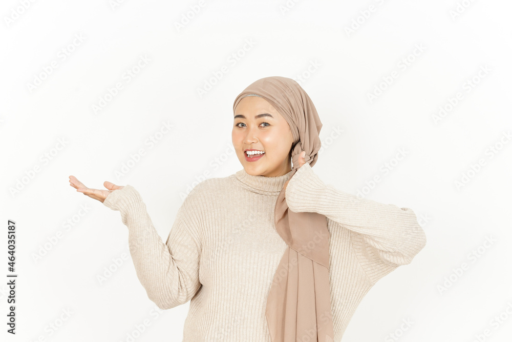 Presenting product on open palm of Beautiful Asian Woman Wearing Hijab Isolated On White Background