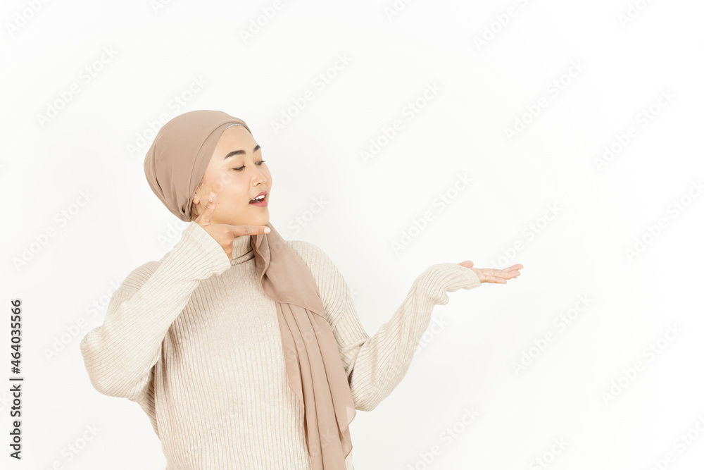 Presenting product on open palm of Beautiful Asian Woman Wearing Hijab Isolated On White Background Presenting product on open palm of Beautiful Asian Woman Wearing Hijab Isolated On White Background