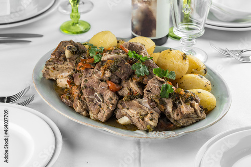 roasted lamb meat with boiled potato and greens on the table