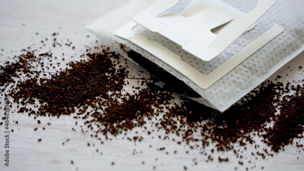 グラインドしたコーヒー豆が散らばっている使い捨てマグペーパードリップコーヒーとコピースペース グラインドしたコーヒー豆が散らばっている使い捨てマグペーパードリップコーヒーとコピースペース