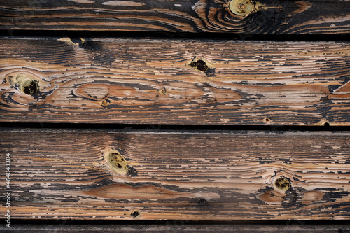 Dark brown wooden boards, planks background. Texture of brown wooden boards, logs with knots. Vintage pattern of rustic oak. Retro wood fence, desk surface close up.