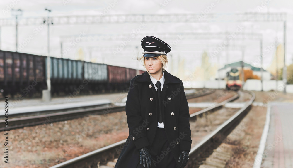 European or American train conductor is on his duty on a platform and other trains. Railway, steam trains .Train controller on the train, near a locomotive European or American train conductor is on his duty on a platform and other trains. Railway, steam trains .Train controller on the train, near a locomotive