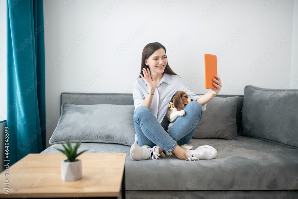 A cute young woman making selfie with her puppy A cute young woman making selfie with her puppy