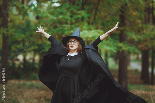 Obraz na płótnie Halloween Witch. Portrait of a girl in a hat and a witch costume in the forest. Ready for trick or treat holiday
w salonie