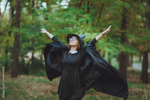 Obraz na płótnie Halloween Witch. Portrait of a girl in a hat and a witch costume in the forest. Ready for trick or treat holiday
w salonie