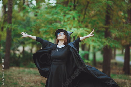 Obraz na płótnie Halloween Witch. Portrait of a girl in a hat and a witch costume in the forest. Ready for trick or treat holiday
w salonie