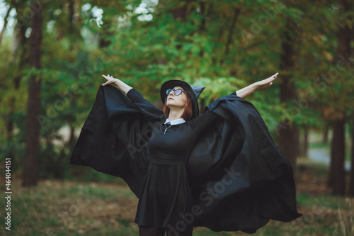 Obraz na płótnie Halloween Witch. Portrait of a girl in a hat and a witch costume in the forest. Ready for trick or treat holiday
w salonie