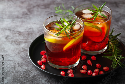 Pomegranate cocktail decorated with lime, rosemary and Ice, cold drink