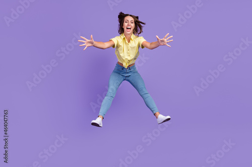Full size photo of impressed millennial brunette lady falling down wear yellow top jeans shoes isolated on violet color background