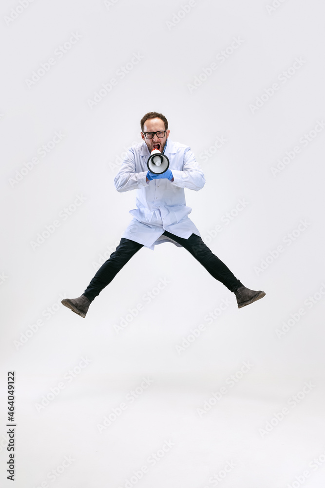 One excited man, chemist, doctor jumping and shouting at megaphone isolated on white background.