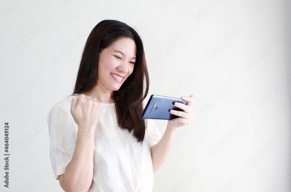 Happy smile asian women looking on smartphone success and winner on online shopping, exam and a good news on white background. Cheerfully. Happy smile asian women looking on smartphone success and winner on online shopping, exam and a good news on white background. Cheerfully.