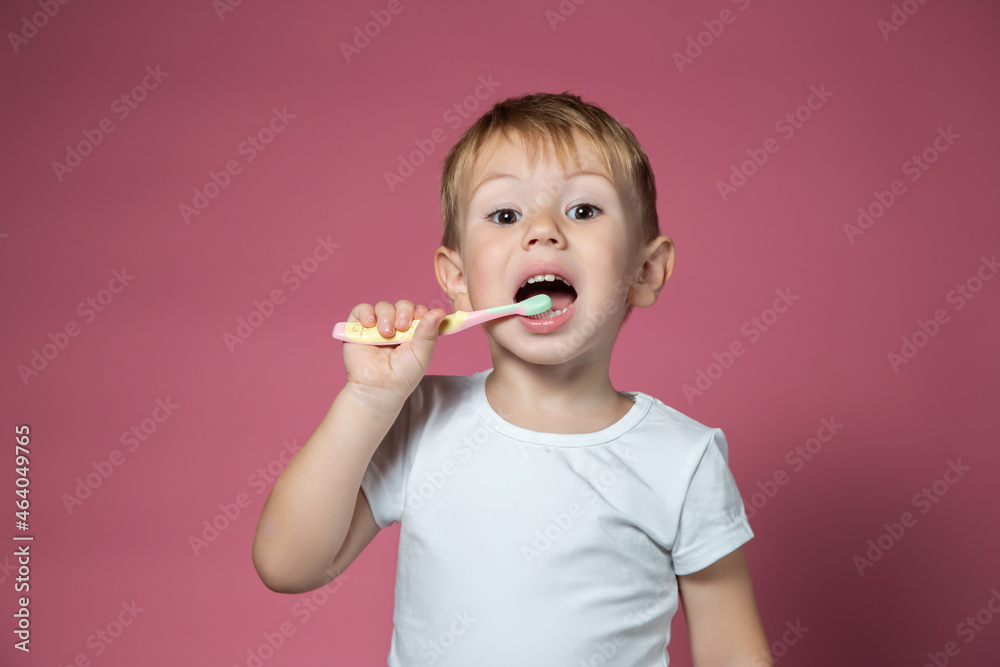 Smiling caucasian little boy cleaning his teeth with manual children toothbrush Smiling caucasian little boy cleaning his teeth with manual children toothbrush