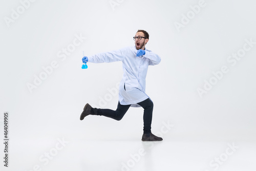 Portrait of running man, chemist, doctor in action and motion isolated on white background. Concept of healthcare, pharmaceuticals, medicine