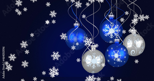 Image of baubles and snow falling on dark blue background