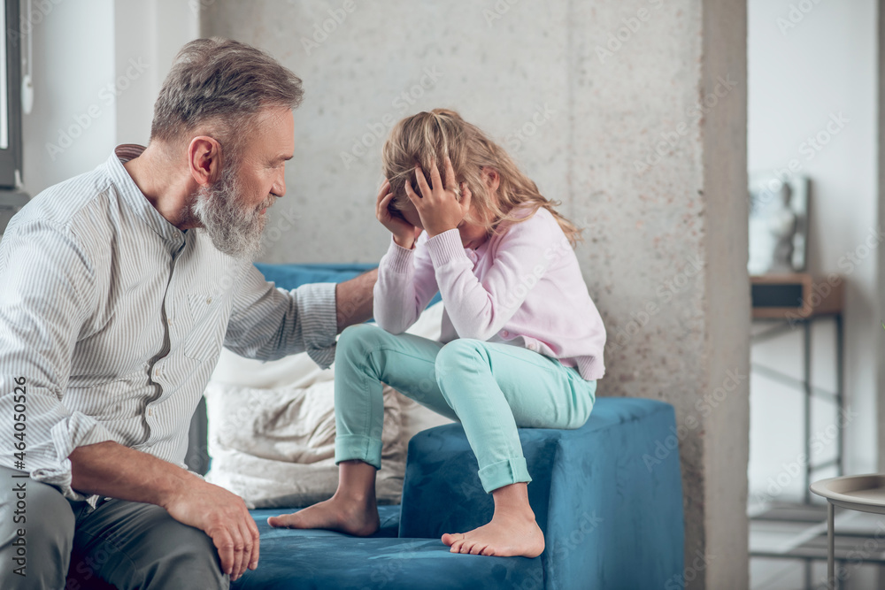 Fototapeta premium A man talking to his upset little daughter