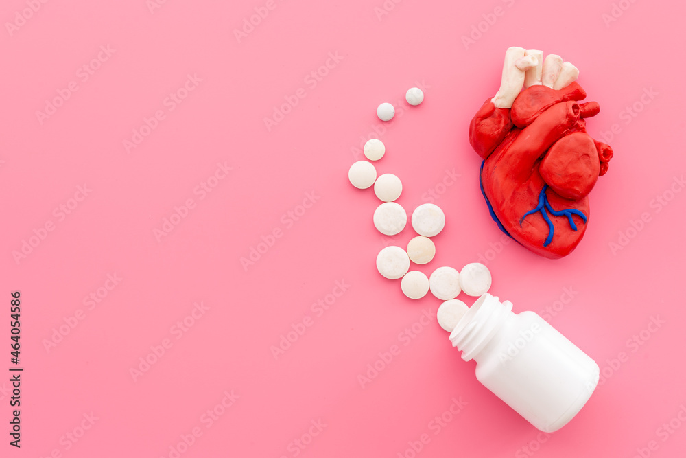 Human heart model with pills top view. Cardioigy and heart health concept