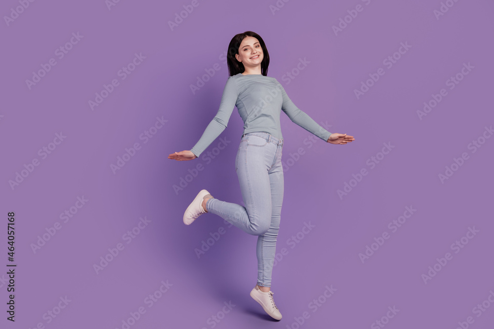 Full size profile side photo of young pretty girl jump go walk sale carefree isolated over purple color background Full size profile side photo of young pretty girl jump go walk sale carefree isolated over purple color background
