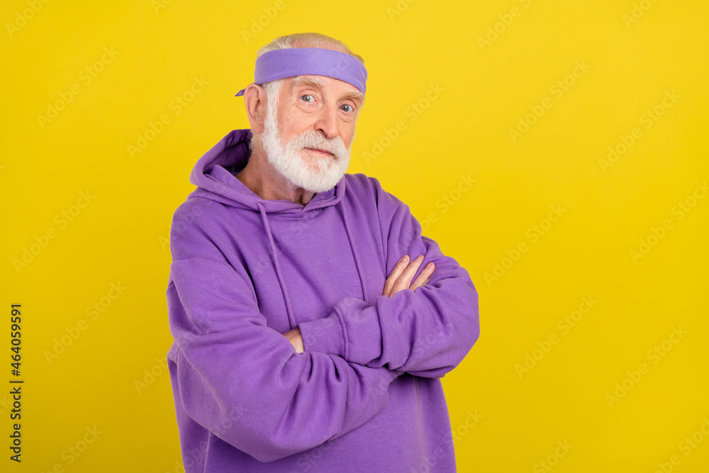 Profile side photo of mature man confident crossed hands sportive outfit isolated over yellow color background Profile side photo of mature man confident crossed hands sportive outfit isolated over yellow color background