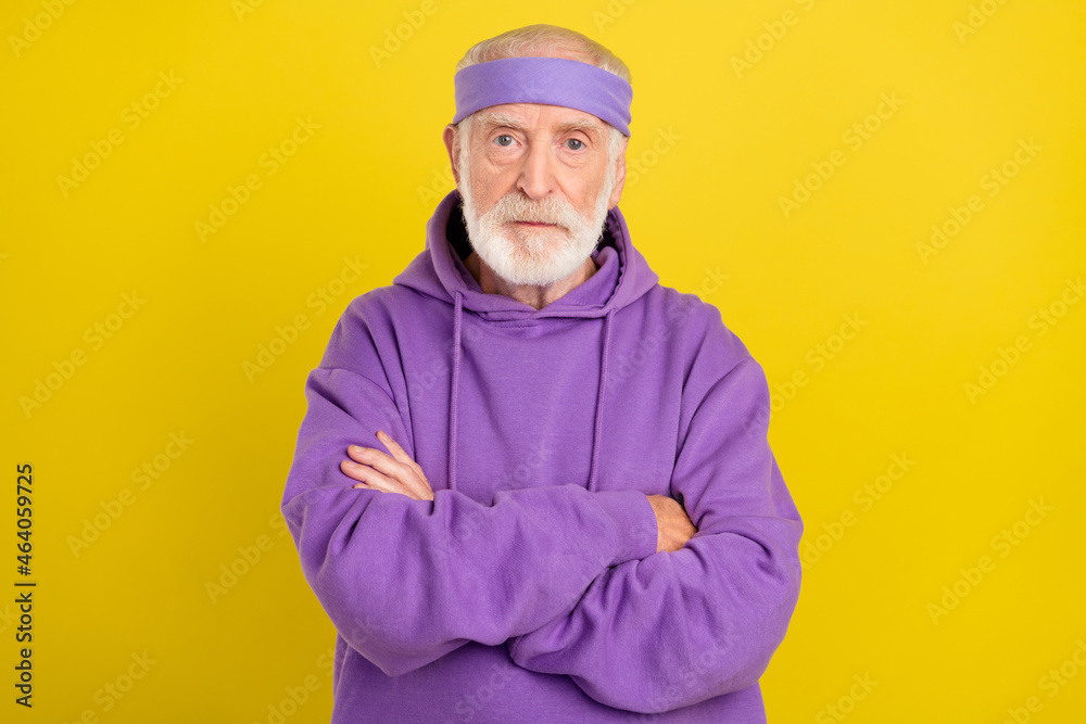 Photo of aged man pensioner crossed hands serious wear sportive clothes isolated over yellow color background