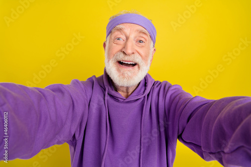 Photo of cheerful aged man blogger take selfie record video sporty isolated over yellow color background © deagreez