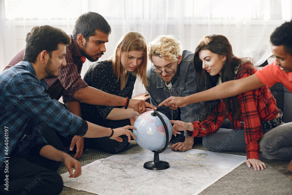 Multi ethnic friends looking at globe at home Multi ethnic friends looking at globe at home