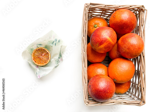 Fotografie Basket of blood oranges and half-blood orange in beeswax food wrap