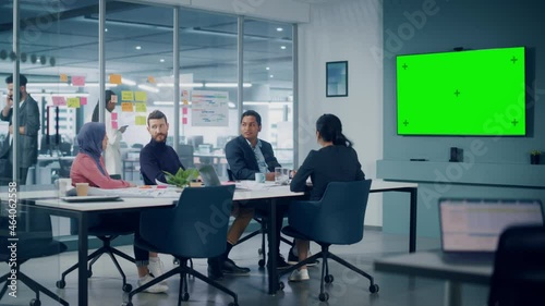 Businesspeople use Green Screen TV in Office Meeting Room. Diverse Team of Creative Entrepreneurs at Big Table have Discussion, Brainstorm. Multi-Ethnic Specialists work in Digital e-Commerce Startup photo
