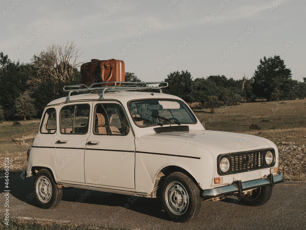 Retro car with suitcase parked in countryside Retro car with suitcase parked in countryside