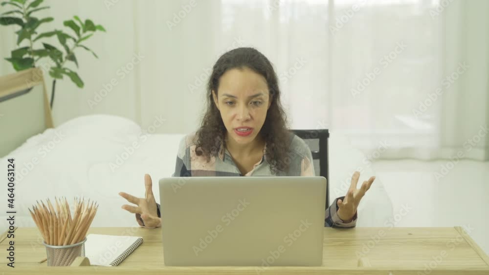 Angry latin young businesswoman shouting and blaming colleagues. People working on computer laptop notebook technology device in bedroom at home. Quarantine lifestyle. Mistake and problem Angry latin young businesswoman shouting and blaming colleagues. People working on computer laptop notebook technology device in bedroom at home. Quarantine lifestyle. Mistake and problem