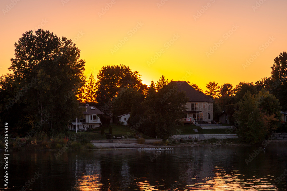 Fototapeta premium Sunset behind large houses on the shore. Ottawa, Ontario, Canada