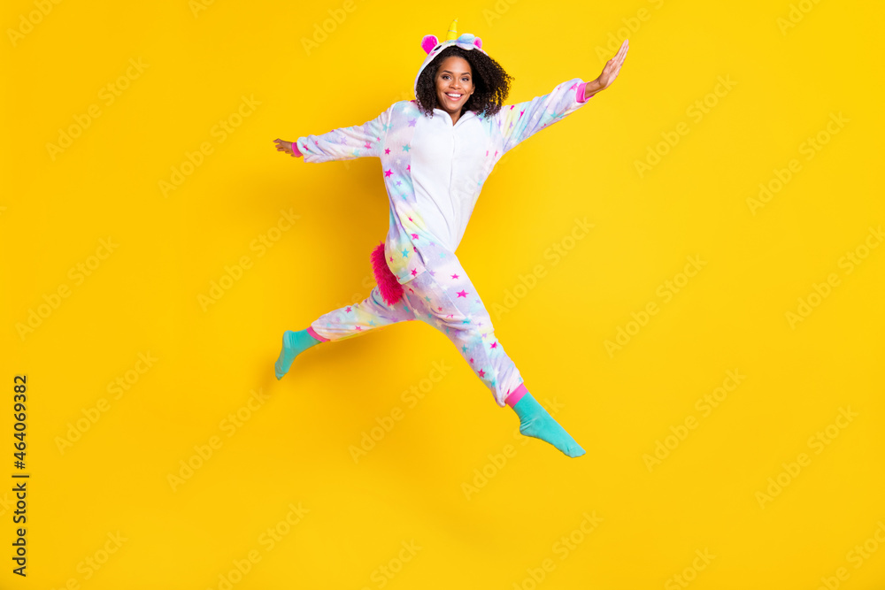 Full body photo of young afro woman happy positive smile jump go walk childish pajamas isolated over yellow color background