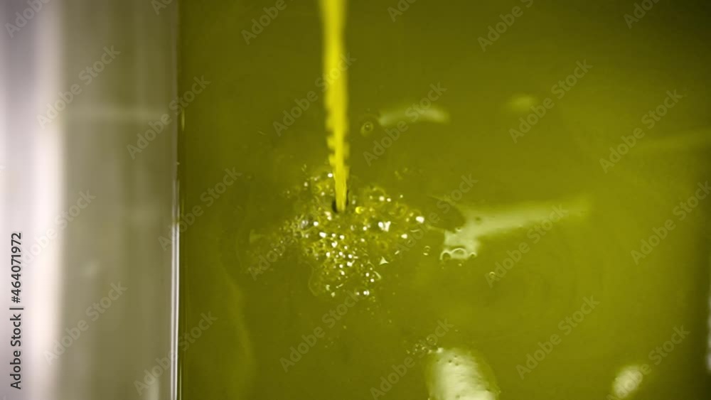 Closeup of an extra virgin olive oil production line. Clean organic extra virgin olive oil is poured into a steel box. Oil mill. Closeup of an extra virgin olive oil production line. Clean organic extra virgin olive oil is poured into a steel box. Oil mill.