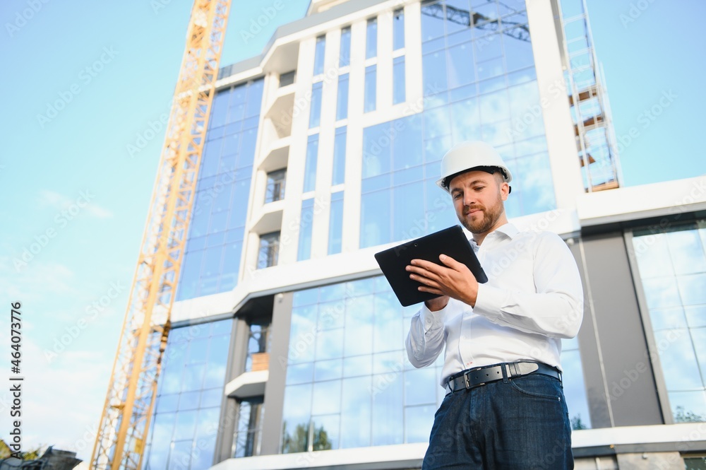 Architect in helmet near new building Architect in helmet near new building