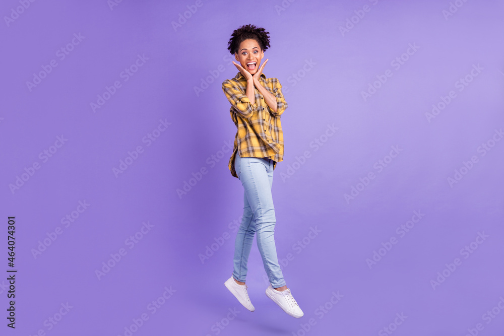 Full length profile side photo of young afro girl happy positive smile jump amazed shocked isolated over purple color background Full length profile side photo of young afro girl happy positive smile jump amazed shocked isolated over purple color background