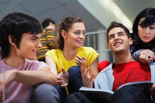 Smiling university students sitting on steps