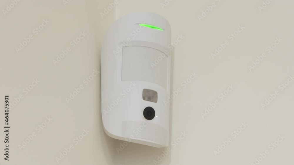 Indoor security system equipment, smart motion detection, wireless motion detector on the wall, infrared sensor sends an alarm signal to security company. High quality 4k footage