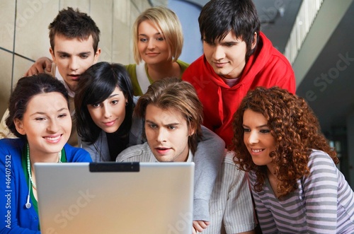 University students using laptop in hallway