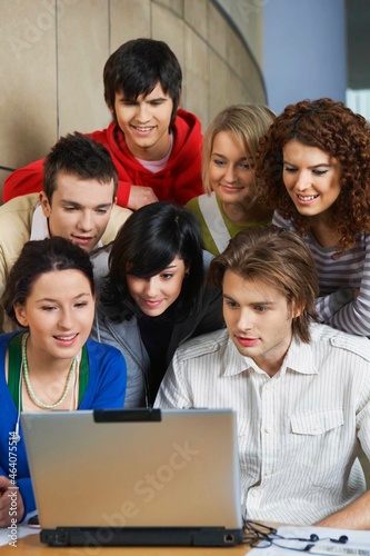 University students using laptop in hallway