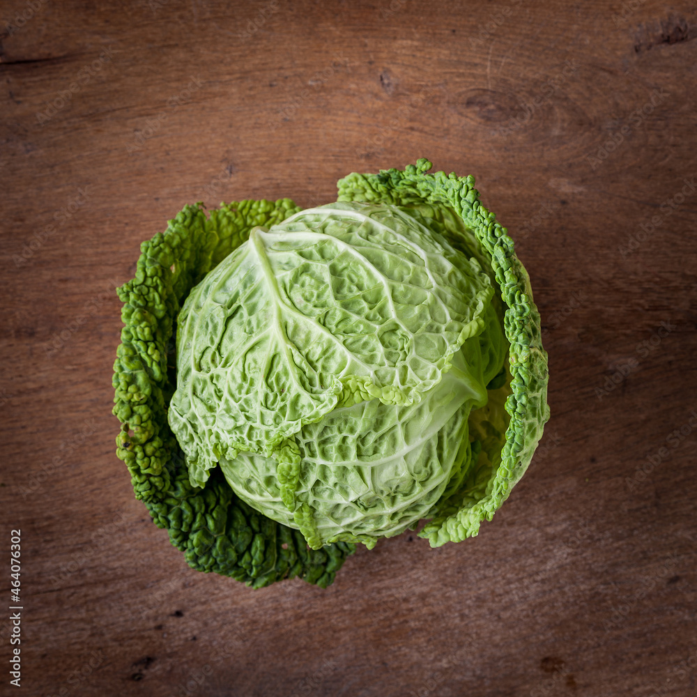 Fototapeta premium Fresh savoy cabbage on wooden background. Harvest concept. Top view.