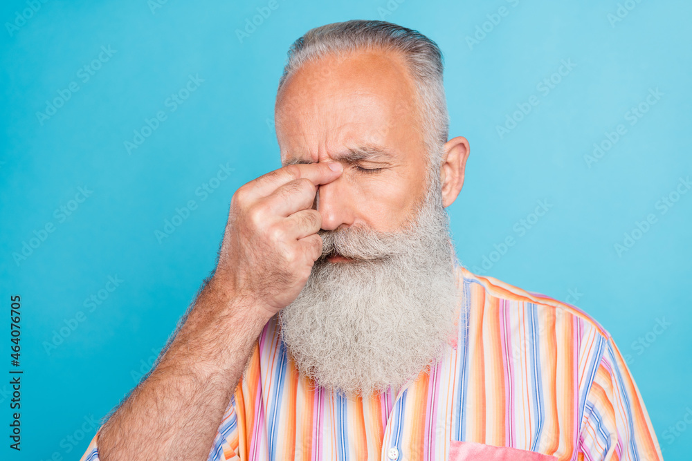 Fototapeta premium Photo of tired ill pensioner man fingers nose bridge suffer headache wear striped shirt isolated blue color background