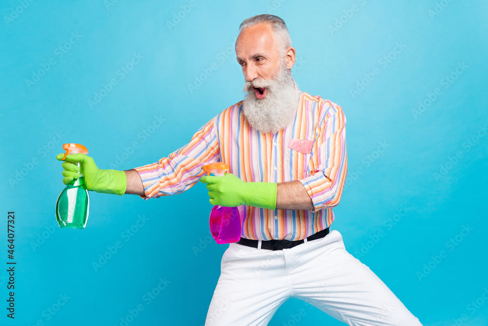 Photo of handsome aged man happy positive smile hold spray cleaner domestic duty isolated over blue color background Photo of handsome aged man happy positive smile hold spray cleaner domestic duty isolated over blue color background